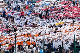 　長崎日大に勝利し、タオルを掲げる有明の応援団＝１３日、甲子園球場