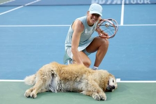　ナショナルバンク・オープンを制し、犬と記念撮影に臨むイガ・シフィオンテク＝１３日、トロント（ゲッティ＝共同）