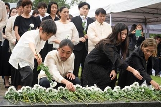 　１５日、フィリピン・ラグナ州カリラヤでの慰霊祭で、並んで献花する参列者ら（共同）