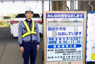 　設置された工事看板と考案者の杉山領人さん＝６日、名古屋市