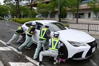 　千葉市役所周辺の道路で、放置車両を動かす市職員ら＝１５日