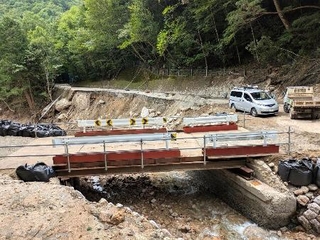 　歩行者と車両の通行が暫定的に再開される仮設橋＝１７日正午ごろ、長野県安曇野市（同県提供）