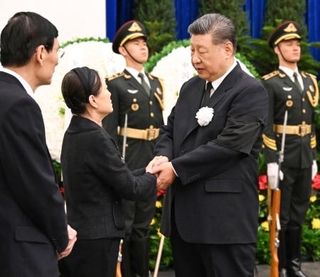 　中国の朱鎔基元首相の告別式に参列し、遺族（左）の手を握る習近平国家主席＝１８日、北京（新華社＝共同）