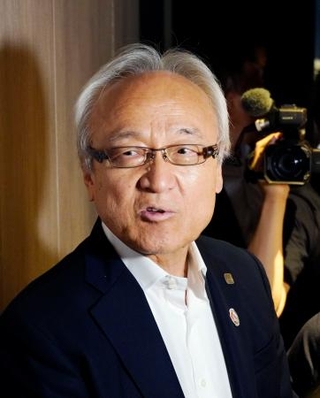 　記者団の取材に応じる福岡県議会の蔵内勇夫議長＝１９日午後、長崎市
