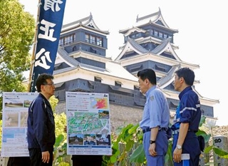 　熊本市の大西一史市長（左）から熊本城の被害状況について説明を受ける木原官房長官（中央）＝２２日午前、熊本市
