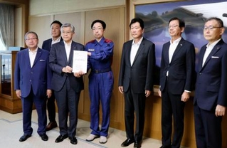 　熊本県の木村敬知事（右から４人目）に要望書を手渡す県内経済６団体の代表者ら＝２４日午前、熊本県庁