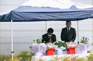 　「楽ん楽ん」跡地に設置された献花台で犠牲者を悼む施設関係者＝３０日午前、岩手県岩泉町