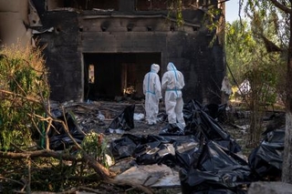 　ロシアによる空爆で亡くなった民間人の遺体を調べる当局者ら＝２９日、ウクライナ・キーウ州（ＡＰ＝共同）