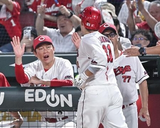 　３回、本塁打を放った坂倉（手前）を迎える広島・新井監督＝マツダ