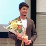 　報告会で写真に納まる中谷潤人＝相模原市