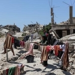 　イスラエルの攻撃で破壊された建物のがれきの中で、洗濯をするパレスチナ人避難民の女性＝３日、ガザ北部ベイトラヒヤ（ゲッティ＝共同）
