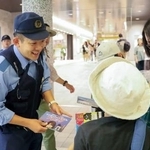 　ＪＲ上野駅構内で詐欺への注意喚起のチラシを配る警視庁の警察官＝４日午前