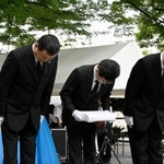 　韓国人被爆者の名簿を奉納する民団広島県地方本部の金基成団長（左）ら＝５日午前、広島市