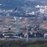 　韓国・坡州から見た北朝鮮との軍事境界線近辺。北側と南側にそれぞれの国旗が掲げられている＝５月（聯合＝共同）