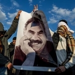 　クルド労働者党（ＰＫＫ）指導者オジャラン受刑者の写真を掲げる人たち＝２０２５年２月、トルコ南東部ディヤルバクル（ＡＰ＝共同）