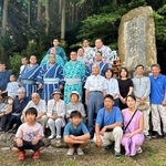 　横綱阿武松の石碑の前で記念撮影する阿武松部屋の力士と地元住民＝１１日、石川県能登町