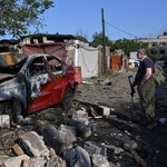 　ロシアの空爆で破壊された車を見る住民＝１１日、ウクライナ南部ザポリージャ（ロイター＝共同）