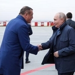 　１２日、ロシア極東ユジノサハリンスクに到着し、サハリン州のリマレンコ知事（左）と握手するプーチン大統領（ロシア大統領府提供・タス＝共同）