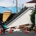 　地震で道路をふさぐように倒壊した家屋＝１２日午後、熊本県八代市