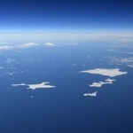 　北海道・根室半島の納沙布岬（左下）沖に広がる北方領土。歯舞群島（中央）、色丹島（右上）、国後島（左奥）。はるか右奥にうっすらと択捉島が見える＝２０１９年１月