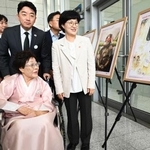 　ソウルで開かれた式典に出席し、慰安婦問題をテーマとした作品を見る元慰安婦の李容洙さん（手前）＝１４日（共同）