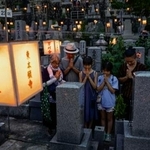 　東本願寺・大谷祖廟の「万灯会」でお参りに訪れ、手を合わせる人たち＝１４日夕、京都市東山区