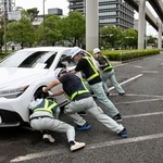 　千葉市役所近くの道路で放置車両を脇に寄せる市職員＝１５日午前、千葉市中央区