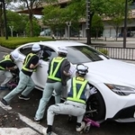 　千葉市役所周辺の道路で、放置車両を動かす市職員ら＝１５日