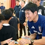 　小中学生らにボールペンを手渡すサッカー日本代表の森保監督＝１６日、熊本県氷川町