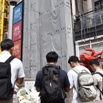 　大阪市の繁華街・道頓堀のビル火災発生から１年となり、現場付近で手を合わせる人たち＝１８日午前