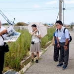 　朝市通り周辺で橋爪朱文さん（左端）から説明を聞く学校関係者ら＝１８日午後、石川県輪島市
