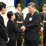 　中国の朱鎔基元首相の告別式に参列し、遺族（左）の手を握る習近平国家主席＝１８日、北京（新華社＝共同）