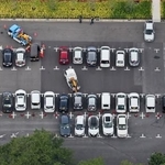 　千葉市役所に隣接する駐車場に運び込まれた、豪雨で動かせなくなり路上などに放置された車両など＝１９日午後（共同通信社ヘリから）