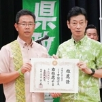 　推薦証を手に写真に納まる自民党の西村選対委員長（右）と元那覇市副市長の古謝玄太氏＝２０日午後、沖縄県浦添市
