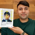 　自著「ことばのヤングケアラー」を手に持つアジズ・アフメッドさん＝１４日、前橋市