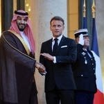 　サウジアラビアのムハンマド皇太子（左）と握手するフランスのマクロン大統領＝２４日、パリ（ロイター＝共同）