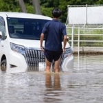 　大雨で冠水した千葉県大網白里市のコンビニの駐車場で立ち往生した車両＝１４日