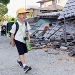 　がれきの脇を歩き、小学校の始業式に向かう児童。久しぶりの登校は楽しみだが、友達が学校にちゃんと来ているか心配しているという＝２８日午前、熊本県八代市