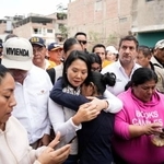　ペルー・リマの豪雨被害が出た地域で、女性と抱き合うケイコ・フジモリ大統領（手前中央）＝１７日（ロイター＝共同）