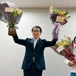 　香川県知事選で再選を決め、花束を手に笑顔の池田豊人氏（左）＝３０日夜、高松市