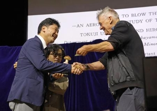 　授賞式に代理で出席し、イグ・ノーベル賞を受け取る旭川医科大の高原幹教授（左）＝３日、スイス・チューリヒ（共同）