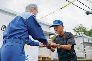 　熊本県氷川町に完成した仮設住宅の鍵を受け取る入居者＝５日午前