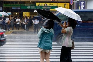 　雨の中、ＪＲ新宿駅前を歩く人たち＝７日午前
