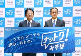 　記者会見でボードを手にする、みずほ銀行の加藤勝彦頭取（左）＝７日午前、東京都千代田区