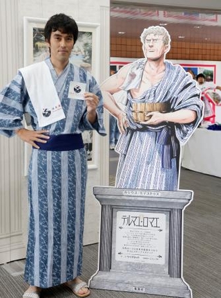 　「温泉文化・世界サミット」の会場に登場した俳優阿部寛さん似の鳥取県職員松田健さん＝７日午後、鳥取県湯梨浜町