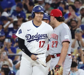 　レッズ戦の７回、四球で出塁し、一塁手スチュワート（右）と笑顔で言葉を交わすドジャース・大谷＝ロサンゼルス（共同）
