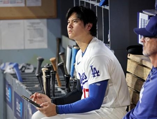 　レッズ戦の８回、ベンチでタブレットを手にするドジャース・大谷＝ロサンゼルス（共同）