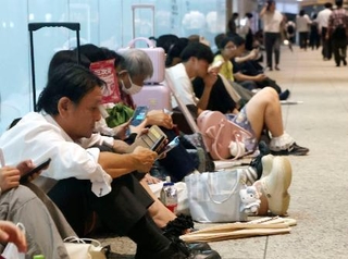 　大雨の影響による帰宅困難者のために開放された名古屋駅近くの商業施設で座り込む人たち＝８日夜