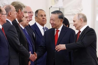 　９日、ベトナムのトー・ラム国家主席（右から２人目）にロシア政権幹部を紹介するプーチン大統領（右端）＝モスクワ（タス＝共同）