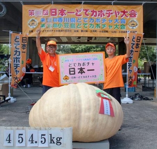 　「日本一どでカボチャ大会」で優勝した田辺憲明さん（左）と３位に入った孫の響人さん＝１３日正午ごろ、香川県土庄町